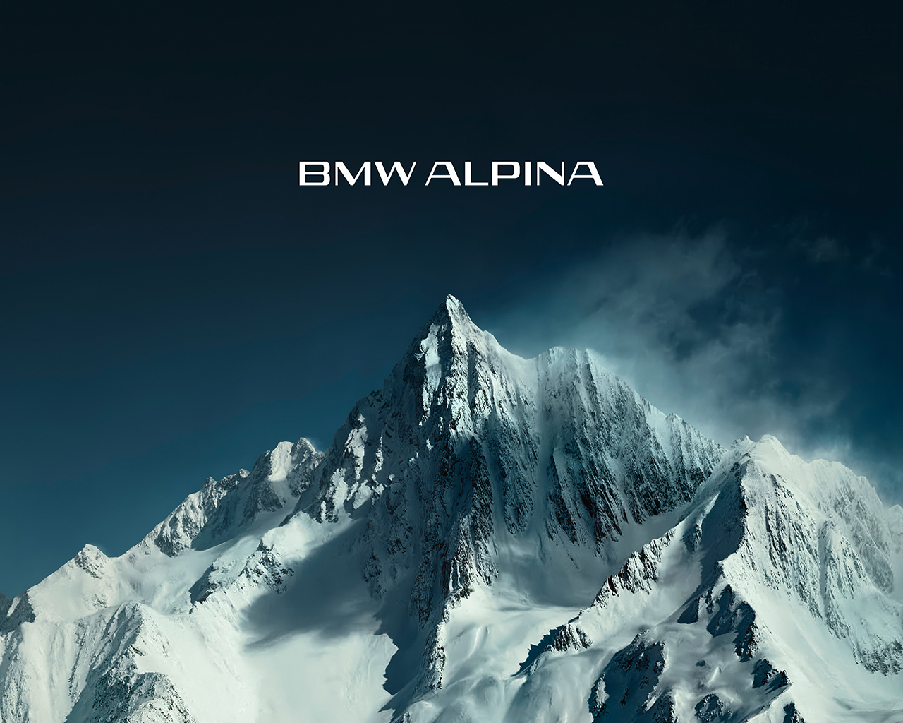 Neuer BMW ALPINA Markenschriftzug vor schneebedeckter Bergkulisse.