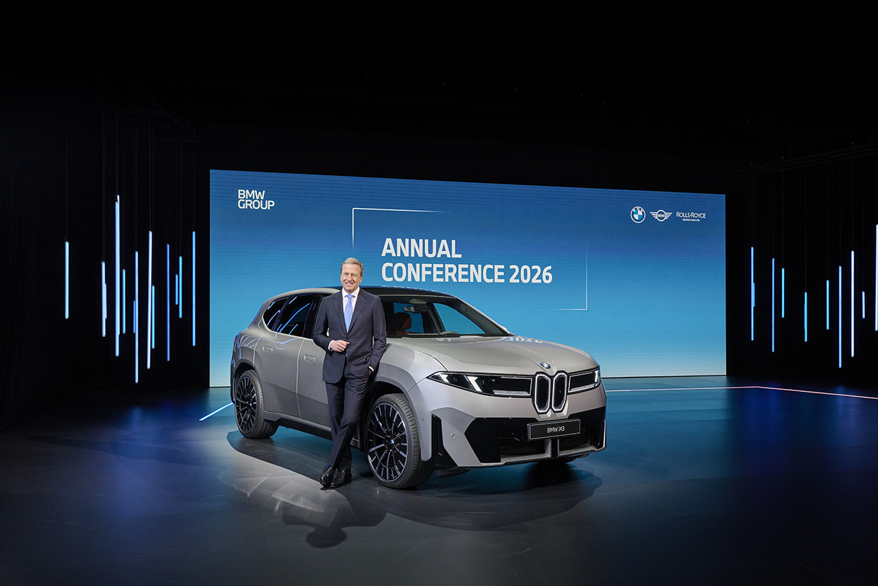 On stage: Oliver Zipse, CEO of BMW AG, stands next to a fully electric BMW iX3 at the BMW Group Annual Conference 2026 in Munich.