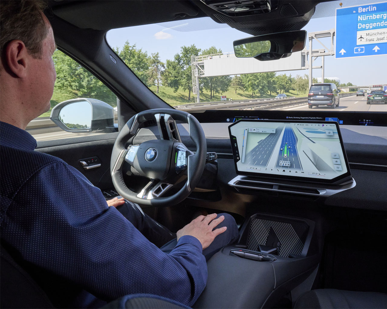 BMW iX3 auf der Autobahn: Mit aktiviertem Autobahnassistenten kann der Fahrer bequem in den Schoß legen, während das Zentral-Display aktive Navigation und Fahrerassistenz zeigt.