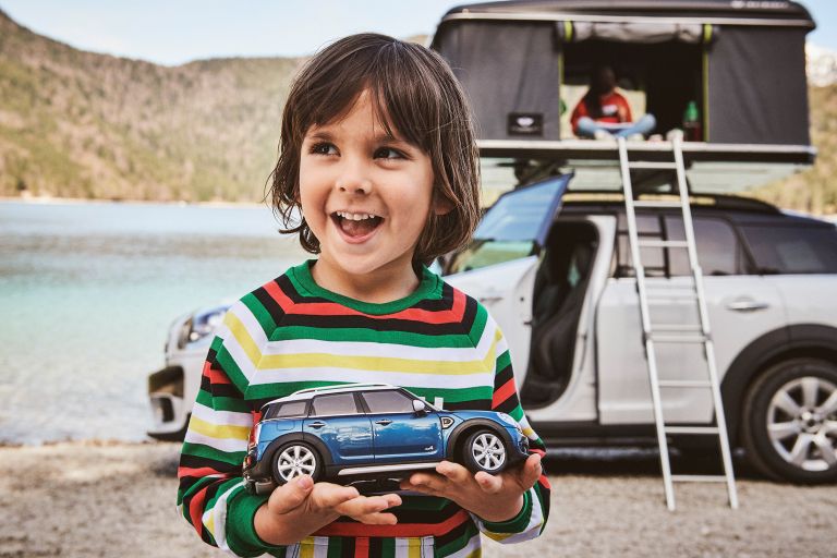 A child holding a MINI toy car