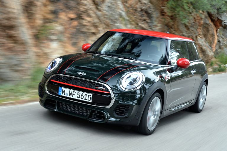 A MINI John Cooper Works 3 door vehicle drives on a rocky road.