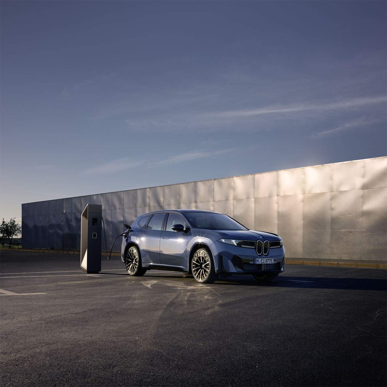 BMW i3 Elektro-SUV, kompakt und umweltfreundlich, geparkt an einer Ladesäule vor einer Metallwand.