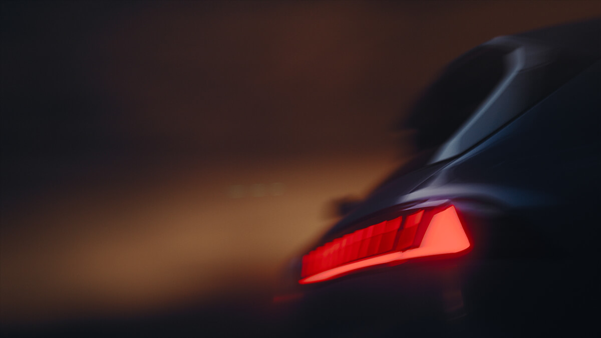 R&uuml;ckseite eines BMW Fahrzeugs mit leuchtendem roten R&uuml;cklicht in diffuser, dunkler Umgebung.