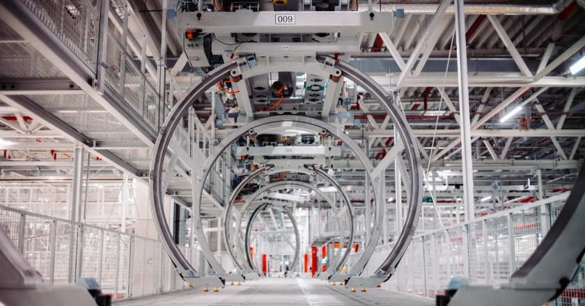 Kreisförmige Transportvorrichtungen einer automatisierten Förderanlage in einer hellen Produktionshalle.