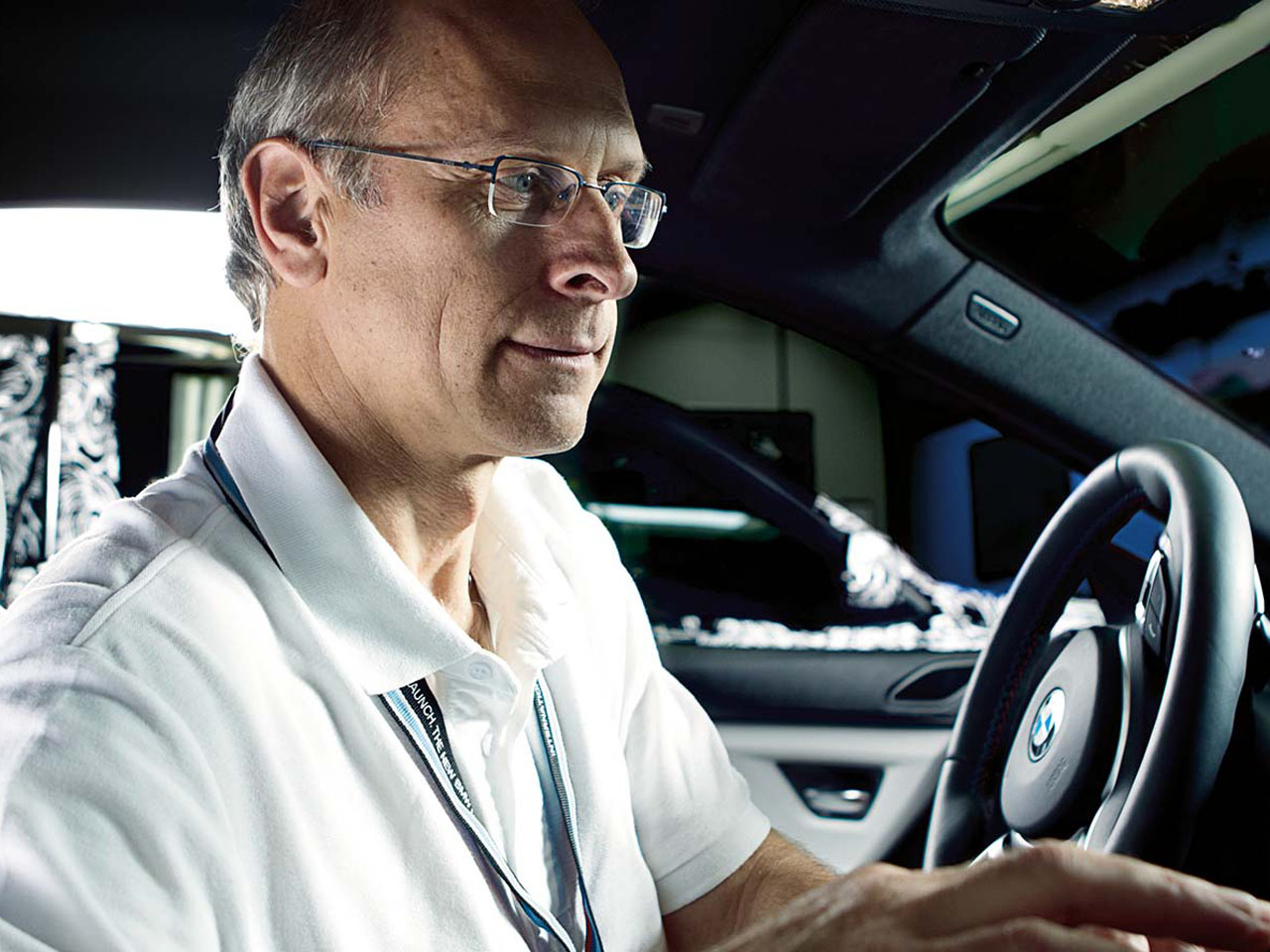 Mann sitzt im Auto und kontrolliert Messgeräte.