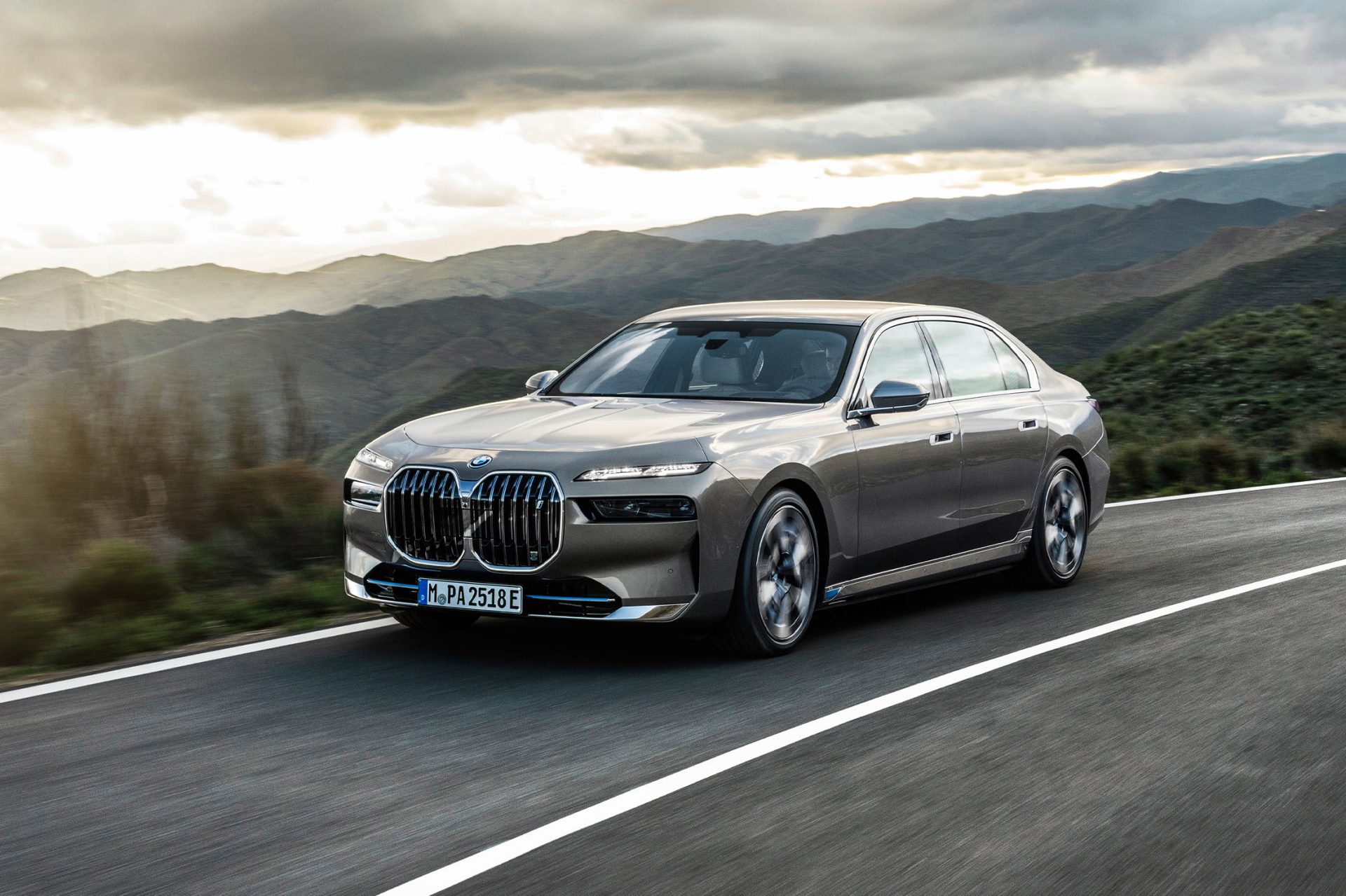Grauer BMW i7 fährt auf einer Landstraße.