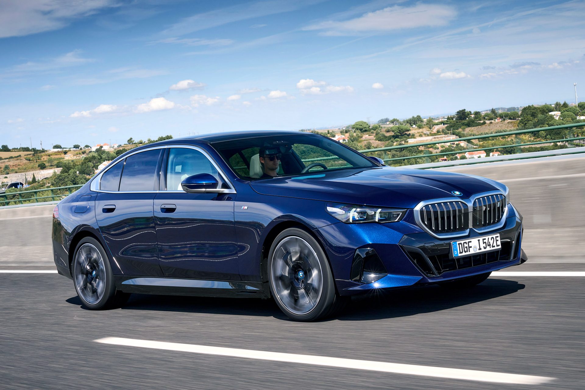 Ein blaer BMW i5 auf der Straße.