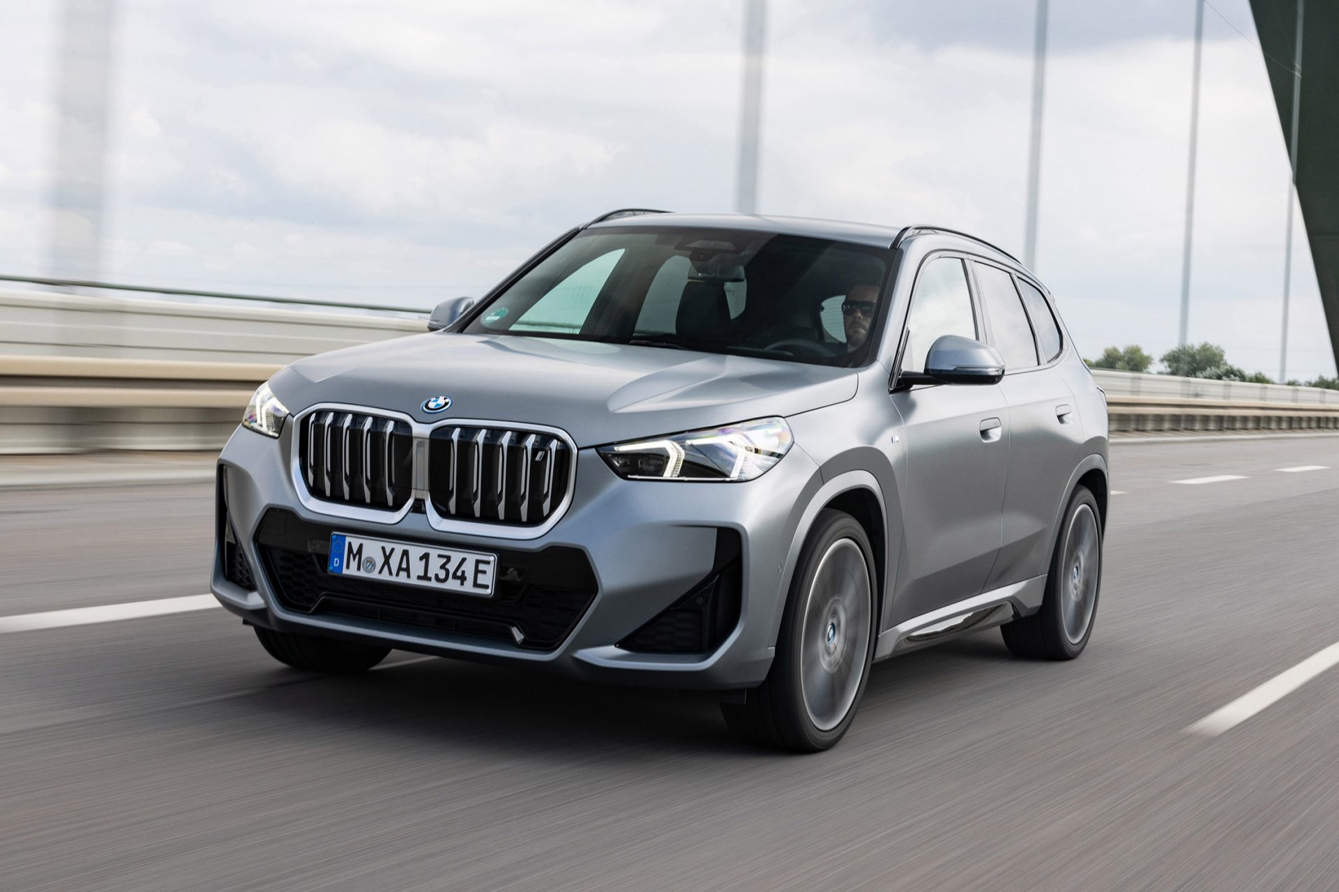 grauer BMW iX1 fährt auf einer Autobahn.