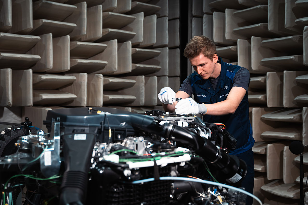 Ein junger Mann montiert Teile an dem BMW Wasserstoffmotor