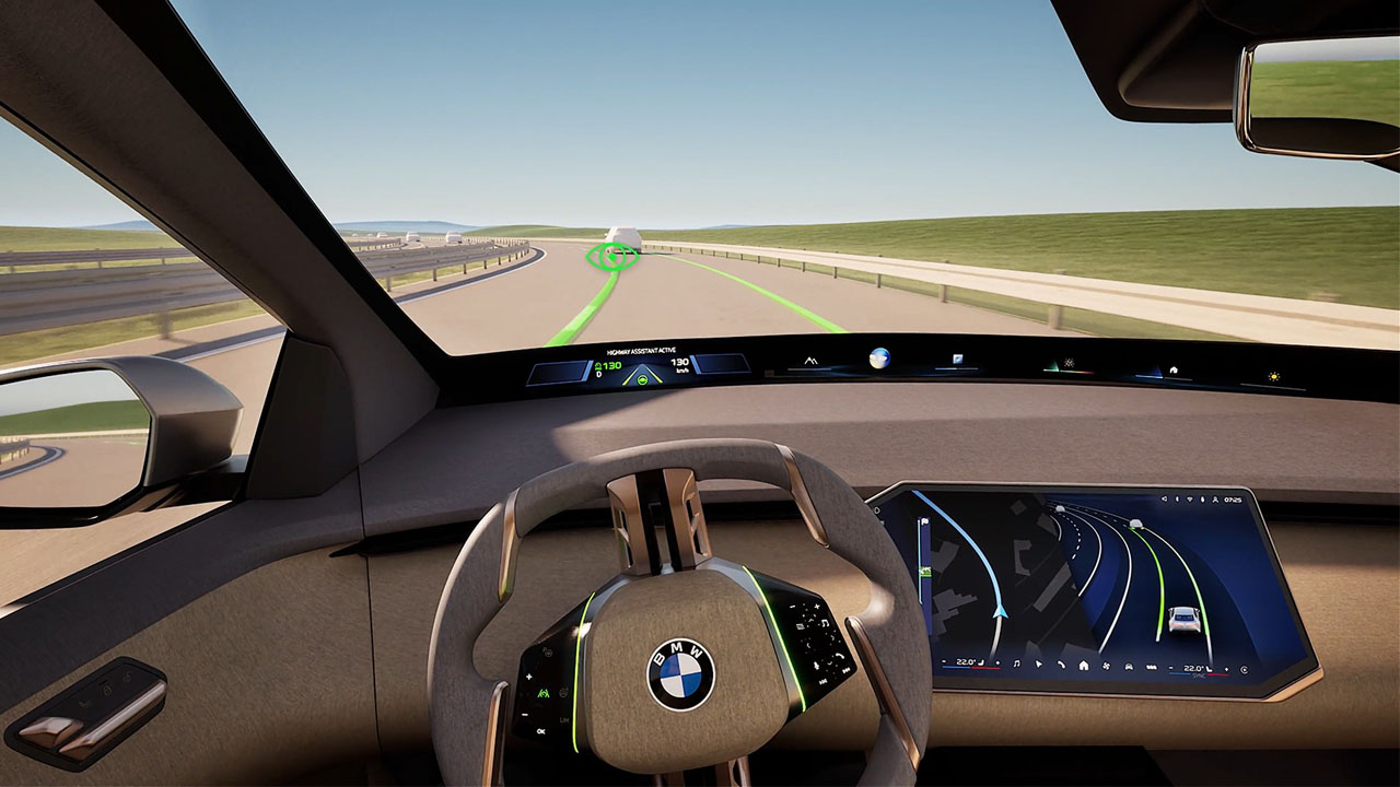 Blick durch die Frontscheibe eines BMW mit Lenkrad und digitalem Armaturenbrett, das Fahrassistenzlinien auf der Straße anzeigt.