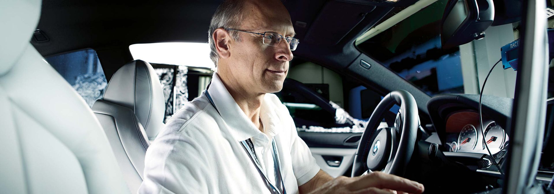 Mann sitzt im Auto und kontrolliert Messgeräte