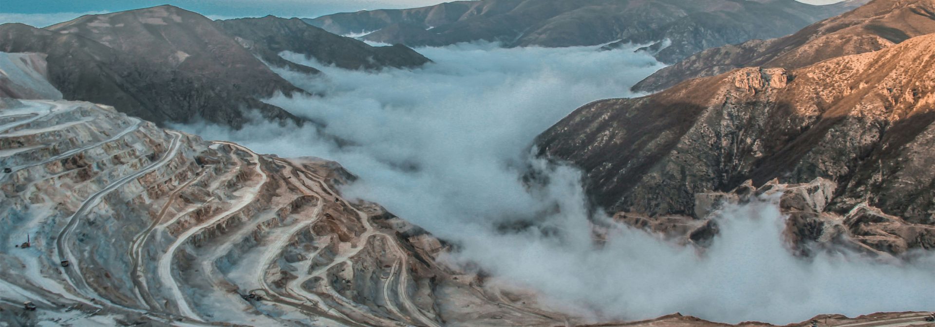 Eine schneebedeckte Bergkette, umgeben von dichten Wolken, die eine majestätische Landschaft bilden.