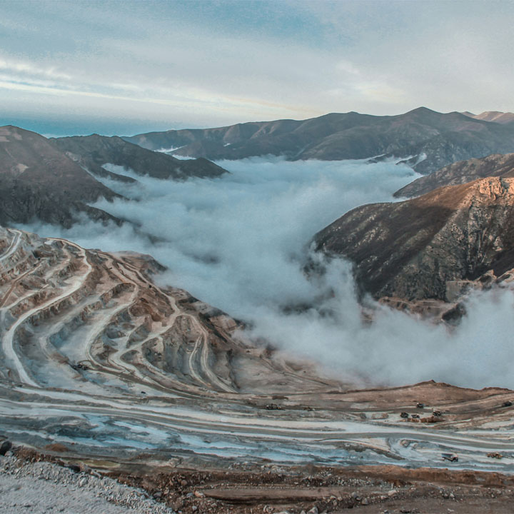 Eine schneebedeckte Bergkette, umgeben von dichten Wolken, die eine majestätische Landschaft bilden.