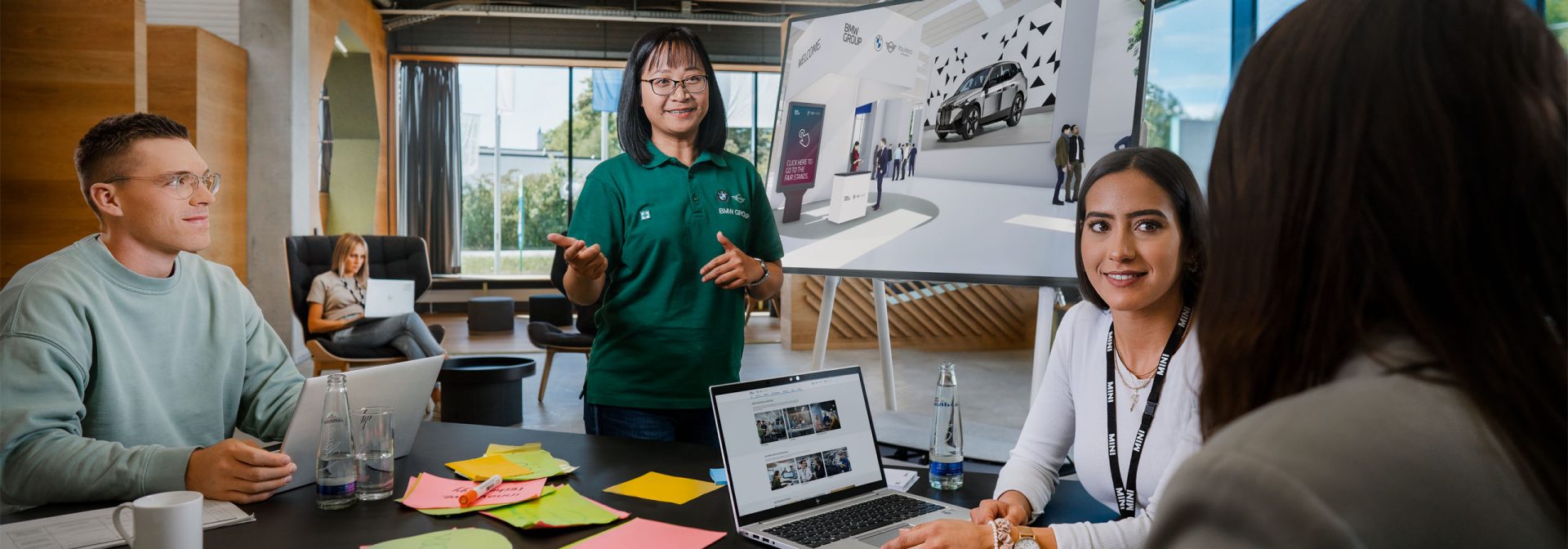 Mehrere Menschen versammeln sich um einen Tisch, auf dem ein Laptop steht.