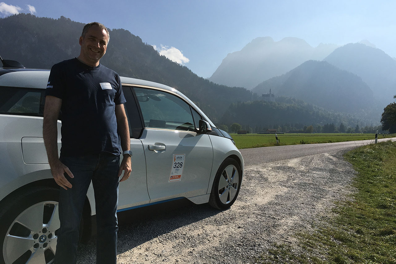Helmut Neumann vor BMW i3 und Gebirge