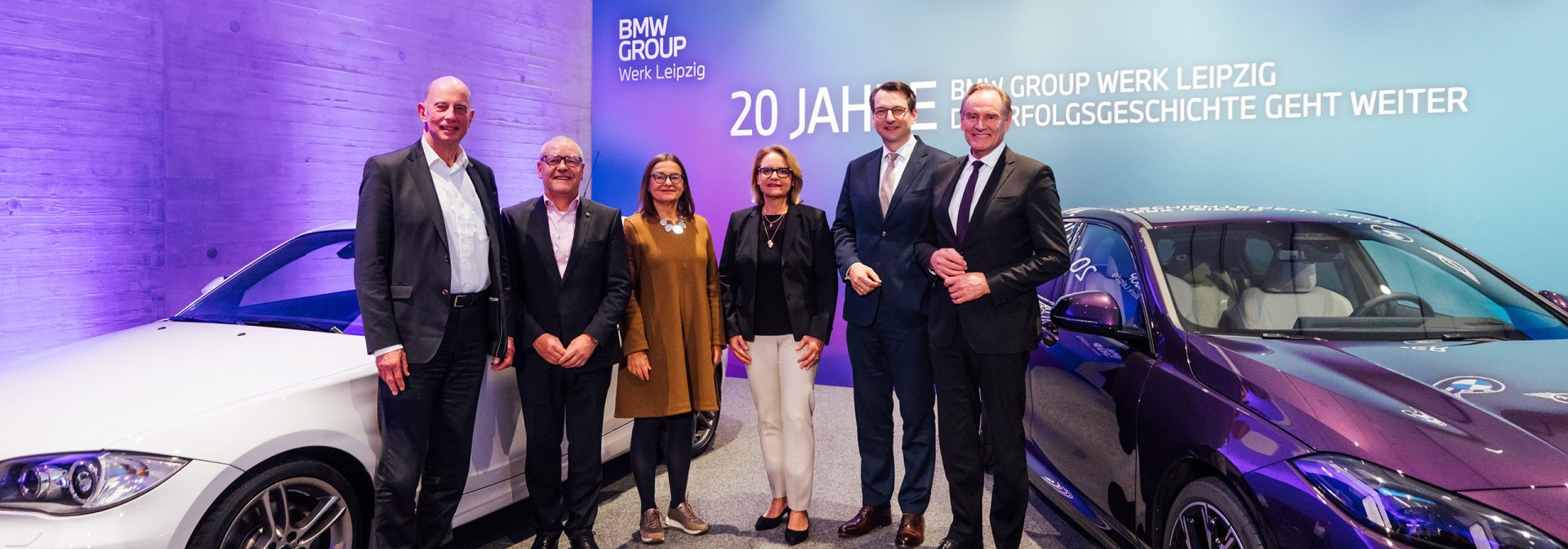 Wolfgang Tiefensee, ehemaliger Oberbürgermeister von Leipzig; Jens Köhler, Betriebsratsvorsitzender BMW Group Werk Leipzig; Barbara Meyer, sächsische Staatssekretärin; Petra Peterhänsel, Leiterin BMW Group Werk Leipzig; Milan Nedeljković, Produktionsvorstand der BMW AG, und Burkhard Jung, Oberbürgermeister von Leipzig, zwischen einem BMW 1er (E87) und einem BMW 2er Gran Coupé (F74).