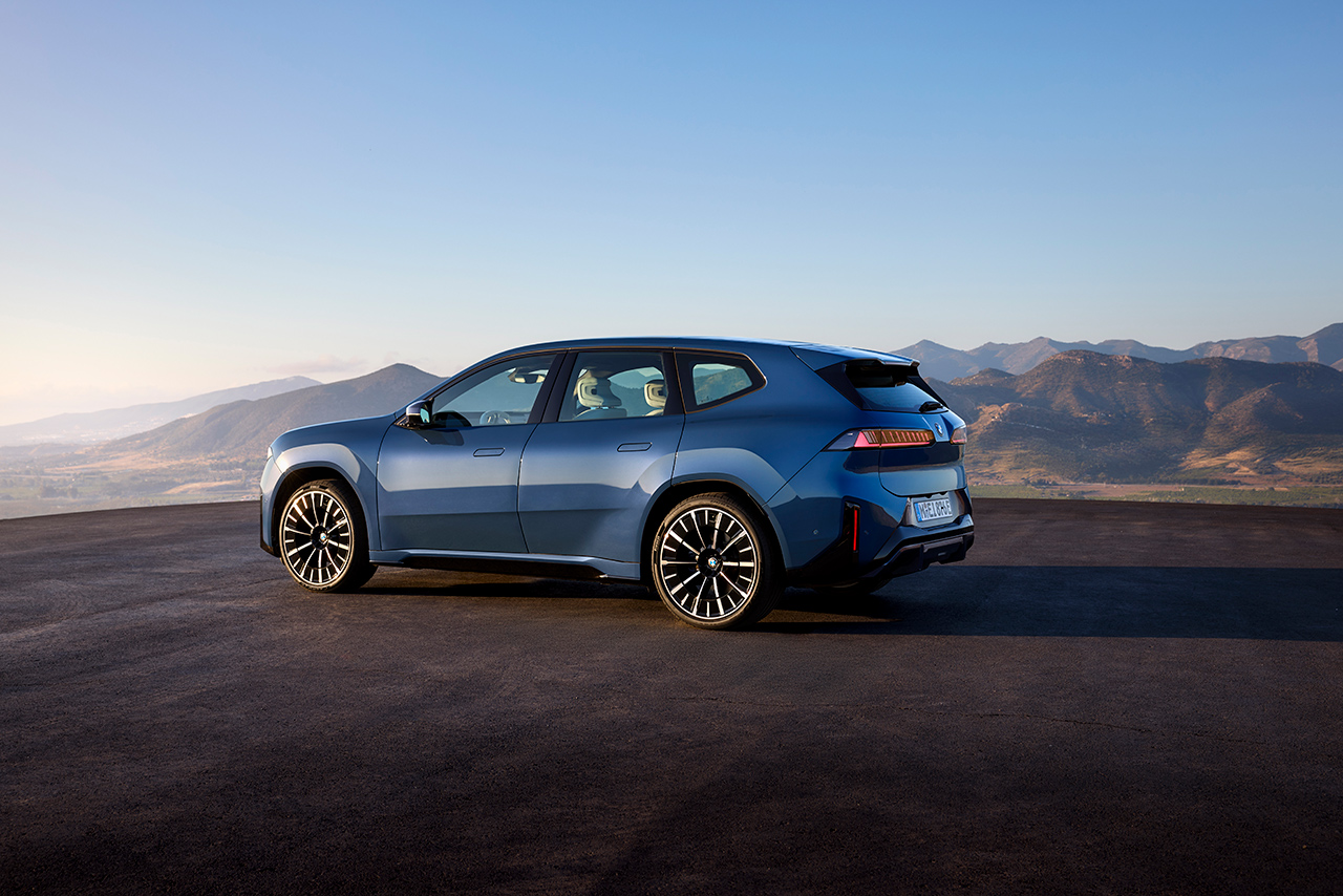 Seitennsicht des neuen BMW iX3 mit beeindruckender Naturkulisse.