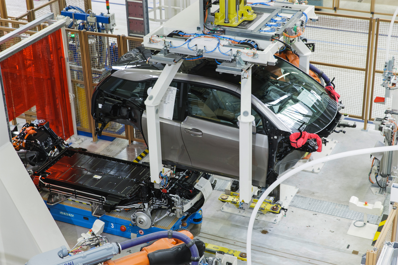 Montageszene im BMW Group Werk Leipzig: ein BMW i3 unmittelbar vor der Verbindung von Karosserie und Fahrwerk („Hochzeit“).