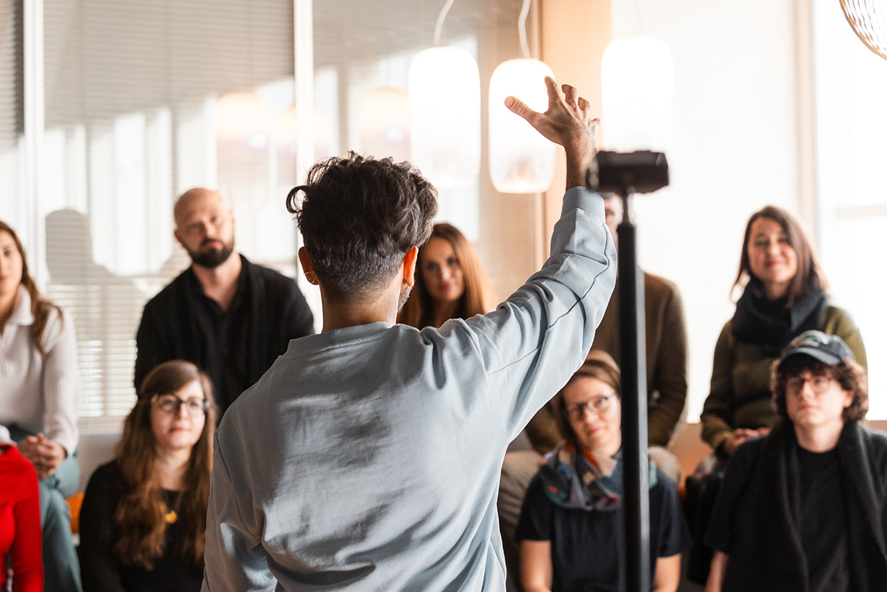 Ein Chor aus Mitarbeitenden des BMW Group Design Studios bei der Aufnahme: Im Vordergrund steht Renzo Vitale als Dirigent.