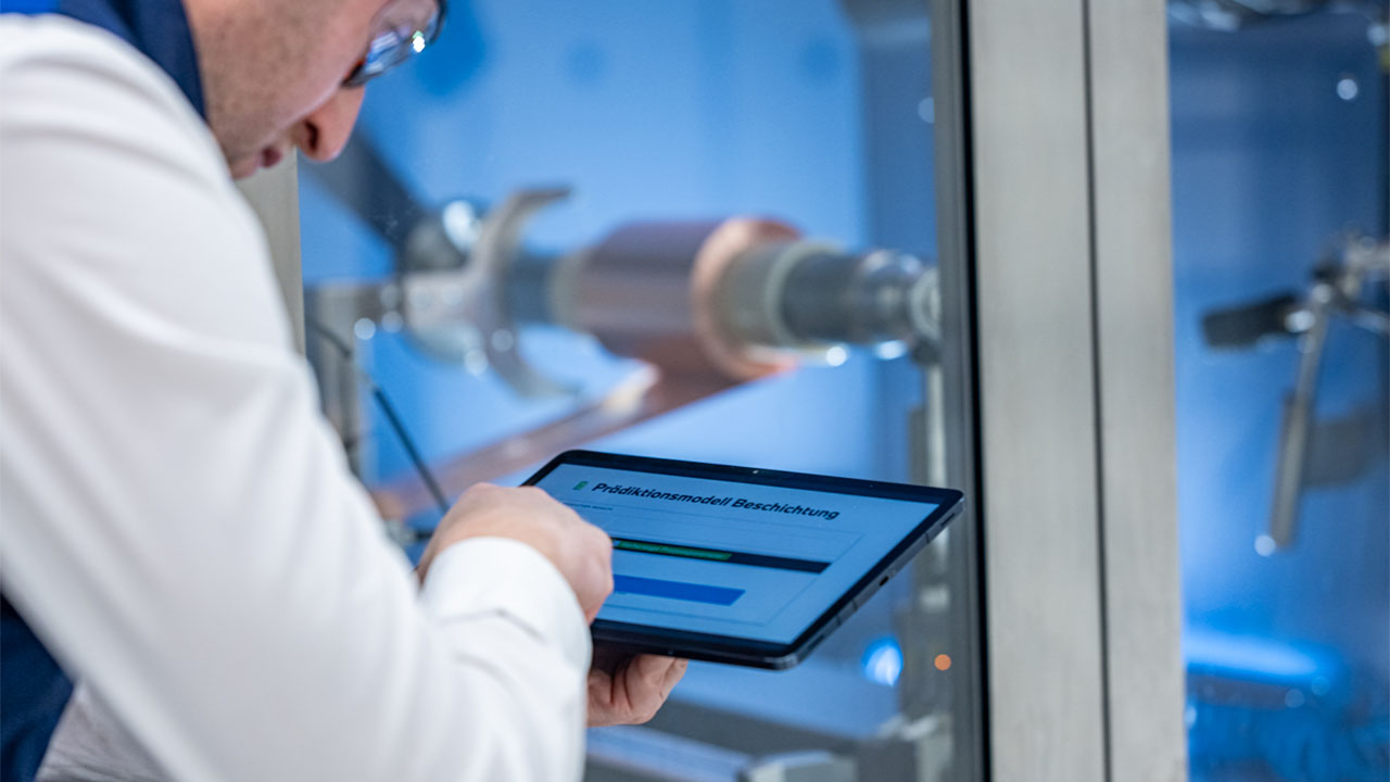 Ein Mitarbeiter der BMW Group nutzt ein Tablet mit einem KI-gestützten Prädiktionsmodell für die Batteriezellfertigung.