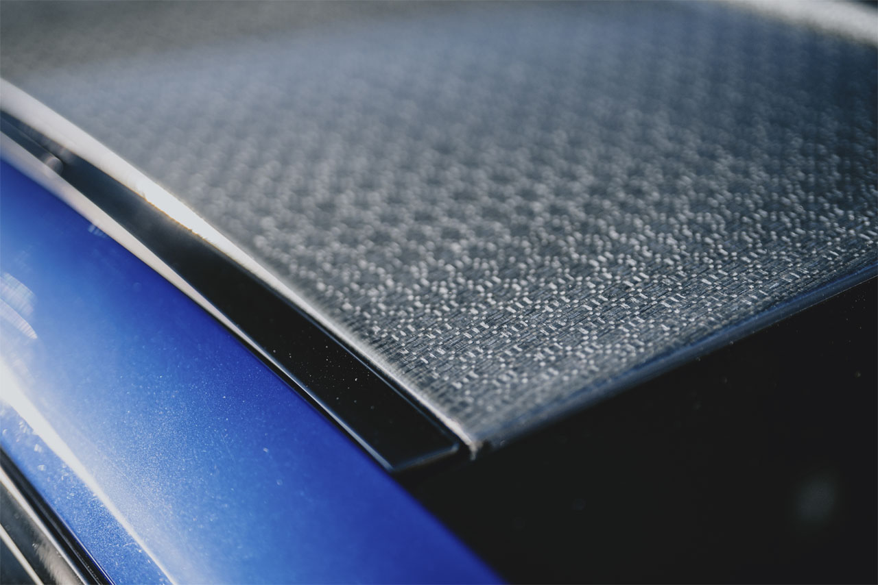 BMW Group Fahrzeug mit blauem Exterieur und Dachmodul aus Naturfaser-Verbundmaterial, Beispiel für nachhaltigen Leichtbau.