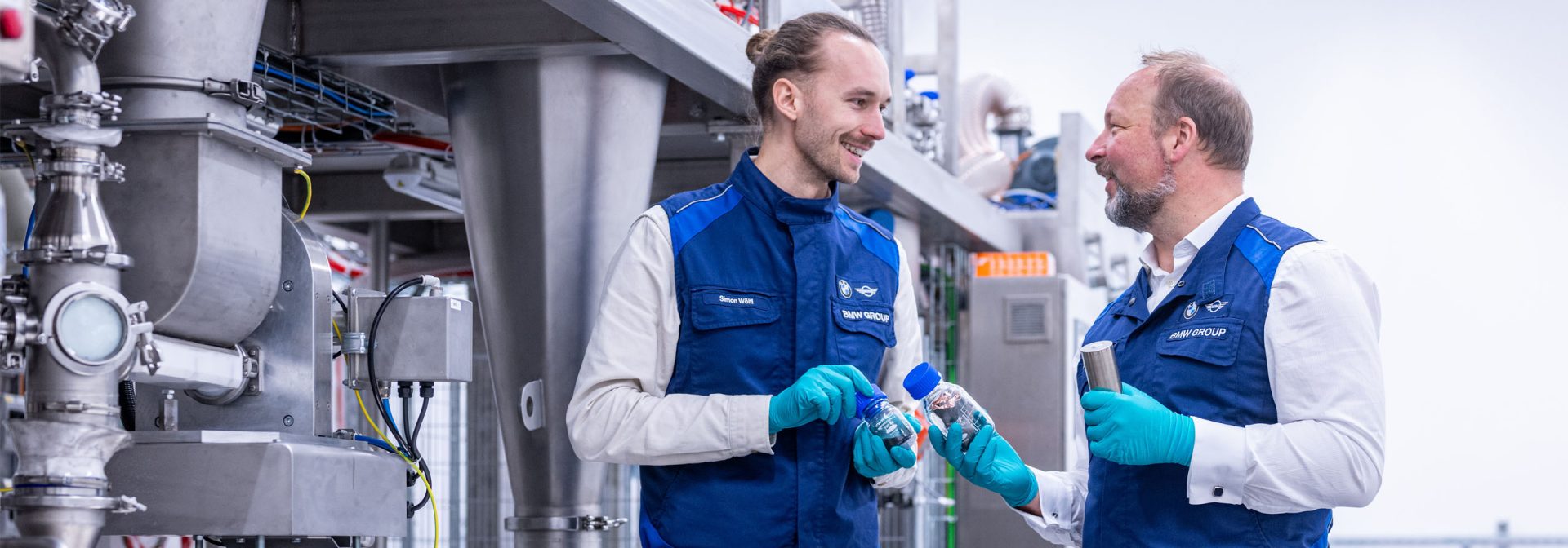 Zwei Experten begutachten Proben recycelter Batterierohstoffe an einer Anlage für Elektrodenrecycling im BMW Group Kompetenzzentrum Batteriezellrecycling (CRCC) in Salching.