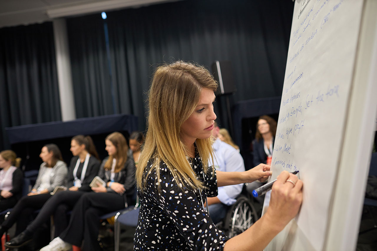 Eine Frau schreibt auf einem Flip-Chart