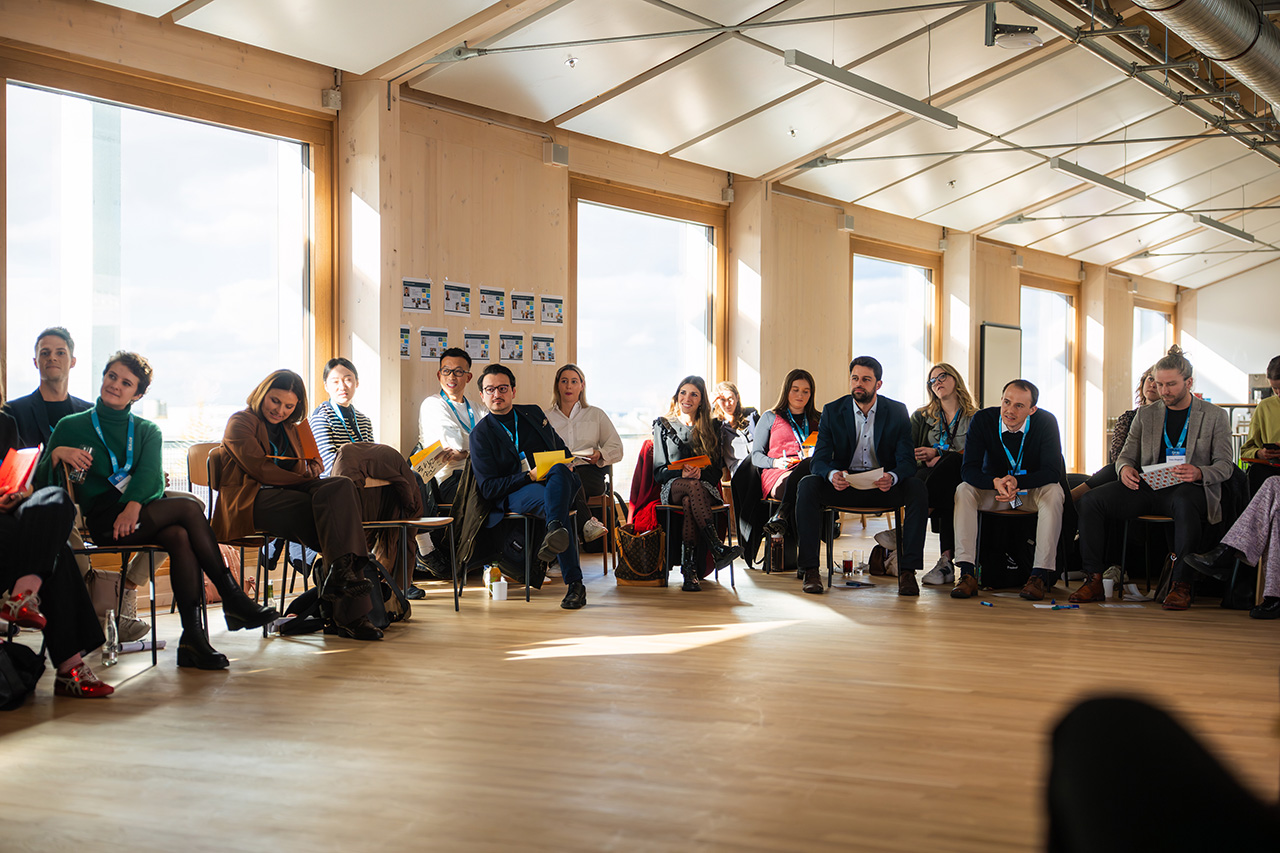 Die Workshop-Teilnehmer sitzen im Kreis auf Stühlen und hören zu.