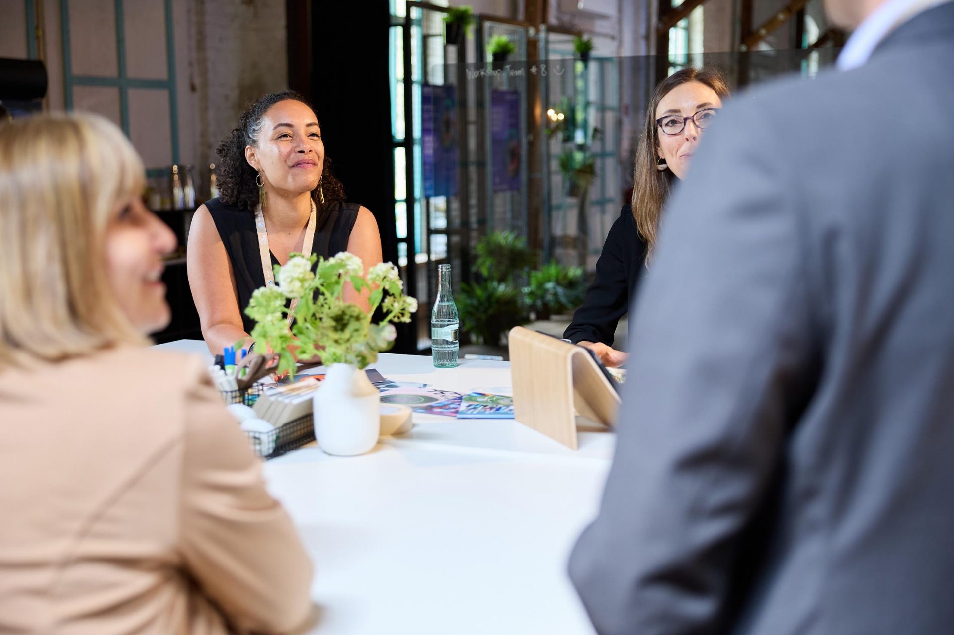  Gruppe von Fachleuten, die an einem Tisch in einem Besprechungsraum diskutieren.