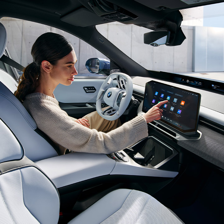 Eine Frau bedient das Touchdisplays Ihres BMW