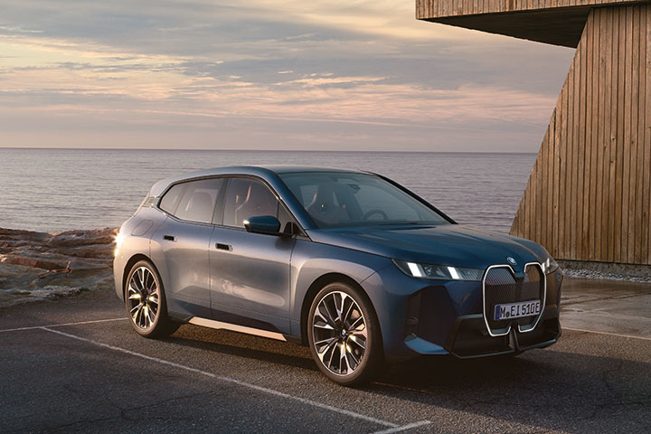 BMW iX auf einem Parkplatz mit dem Meer im Hintergrund geparkt