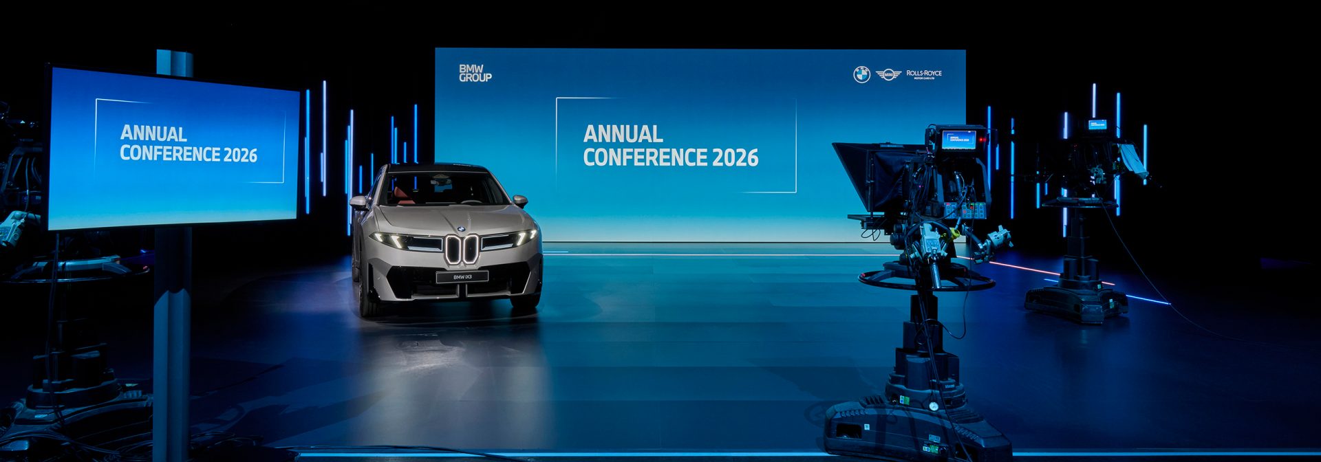 BMW Group Annual Conference 2026 – BMW New Class ix3 in a room in front of the BMW Group advertising banner.