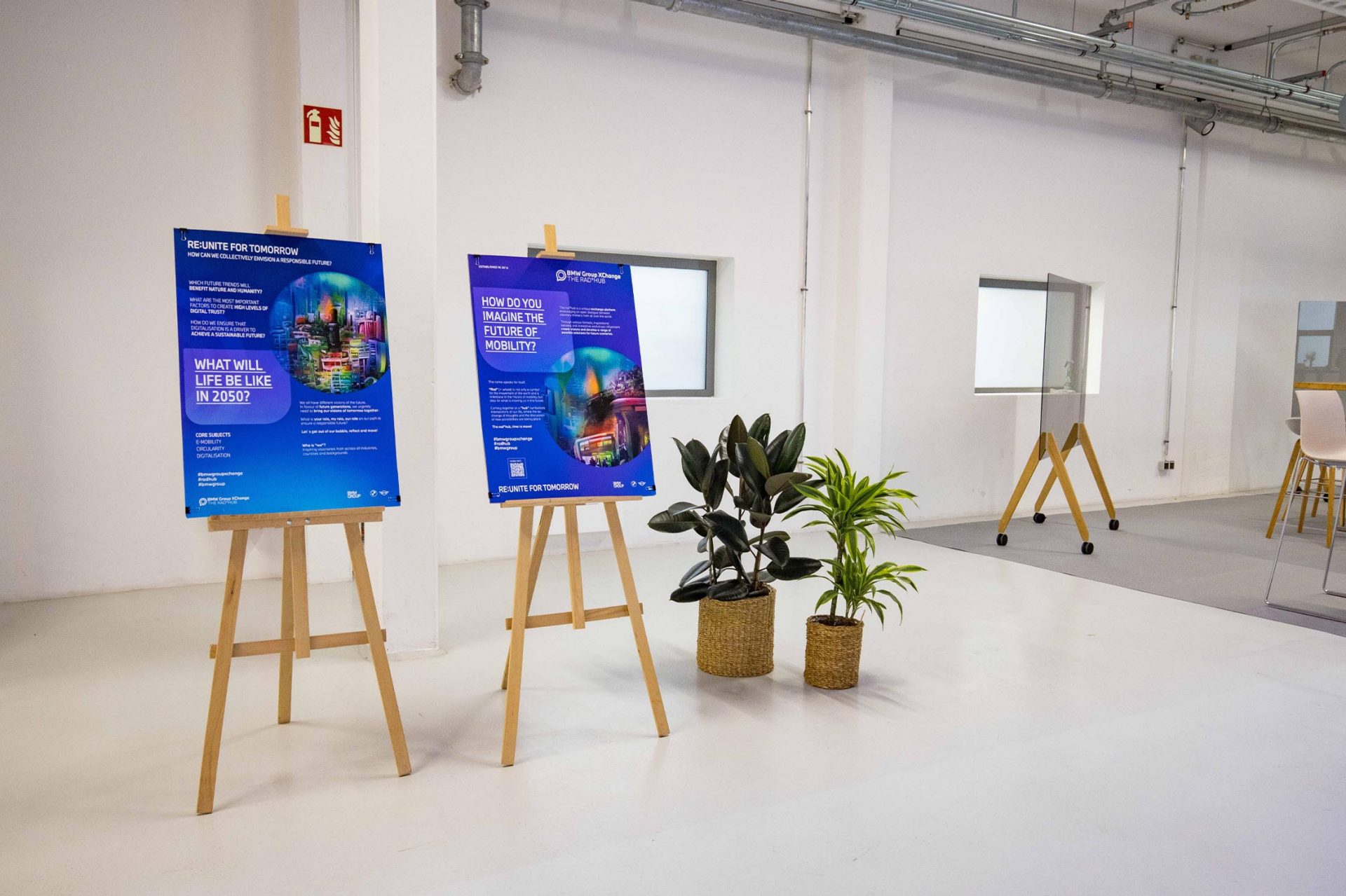   Two posters in a modern room with plants.