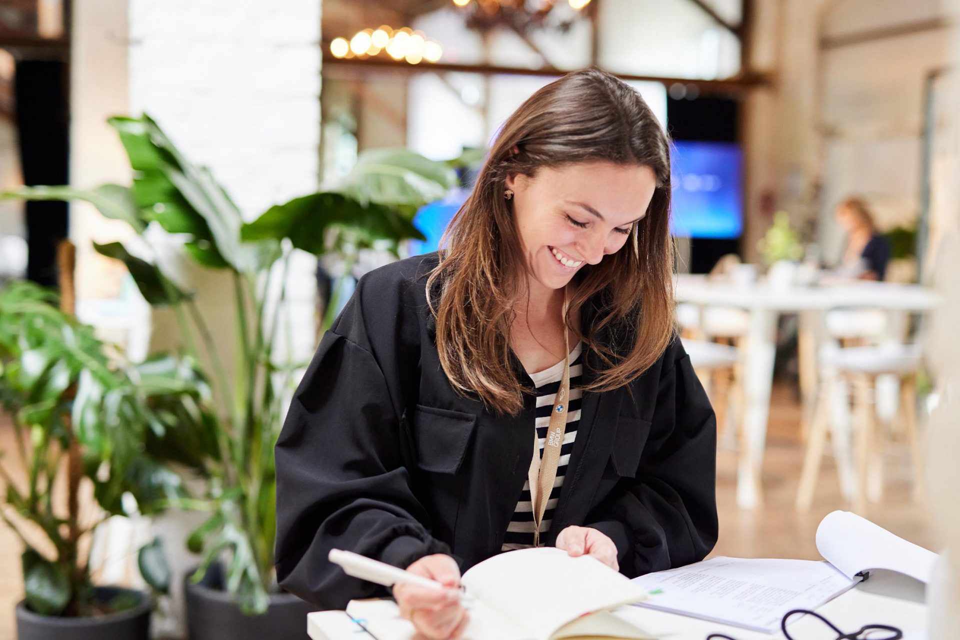 A young woman writing in a book. 