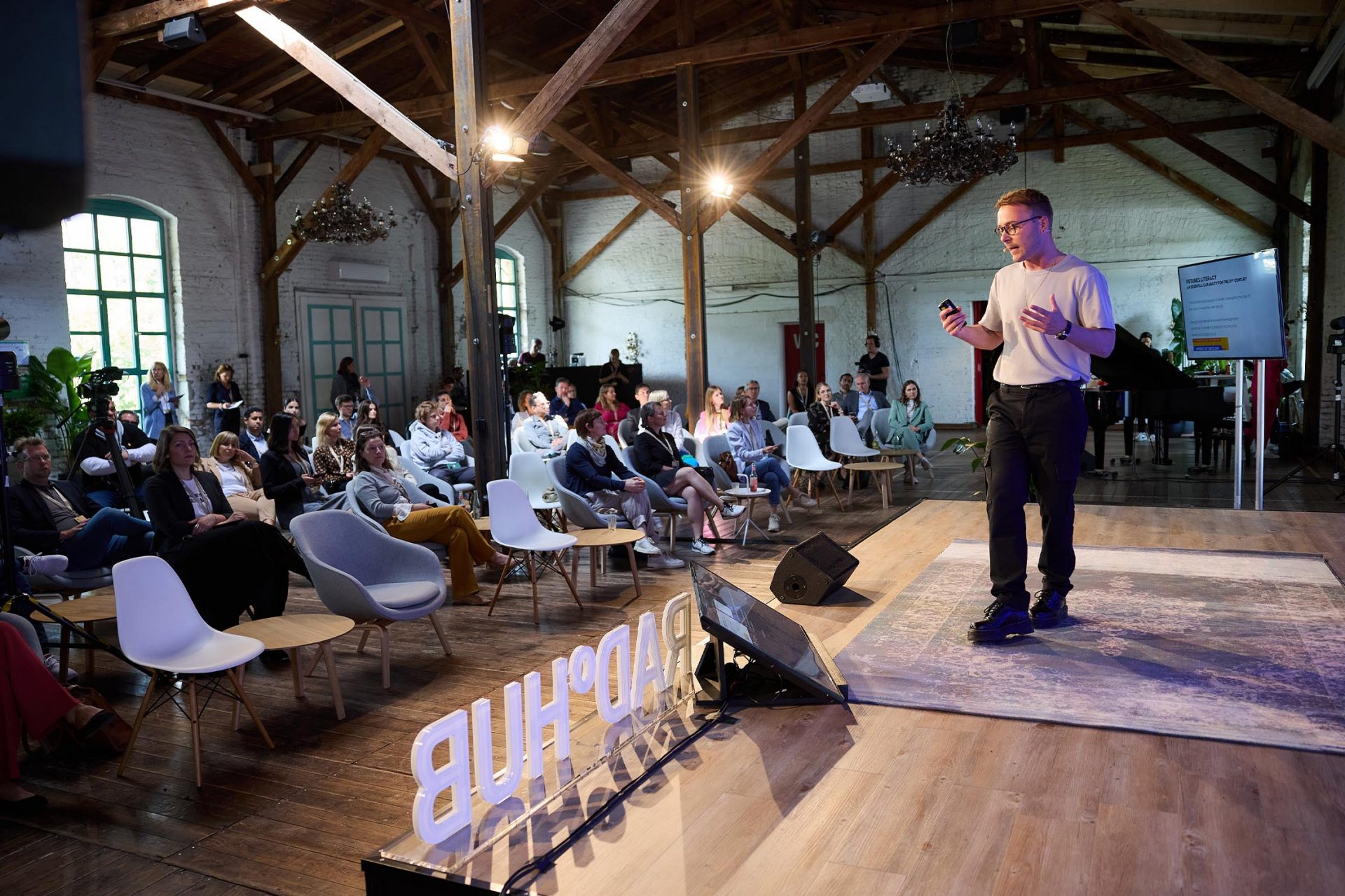   A young man is giving a speech on stage in front of an audience