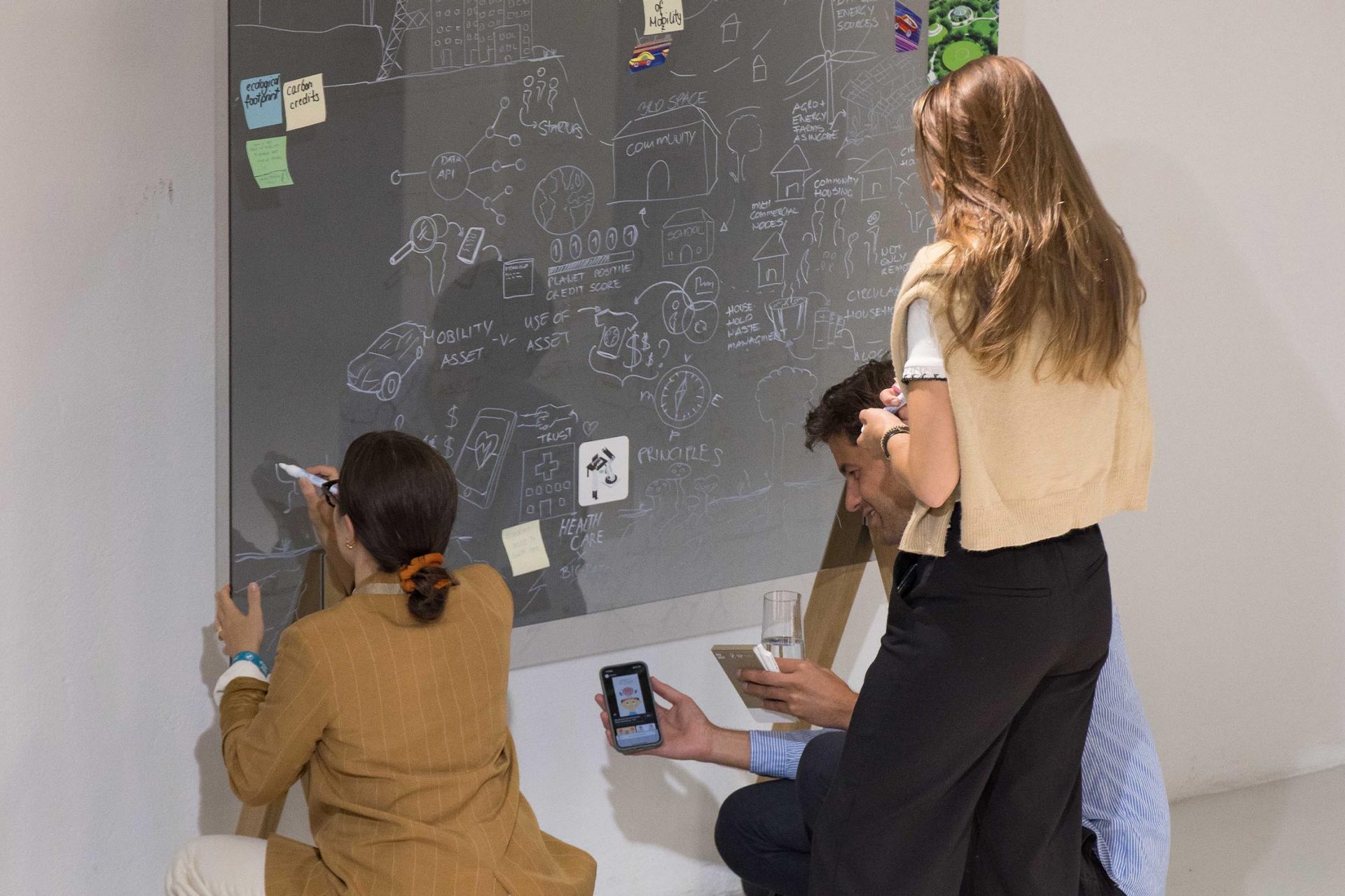   Three people working together at a whiteboard