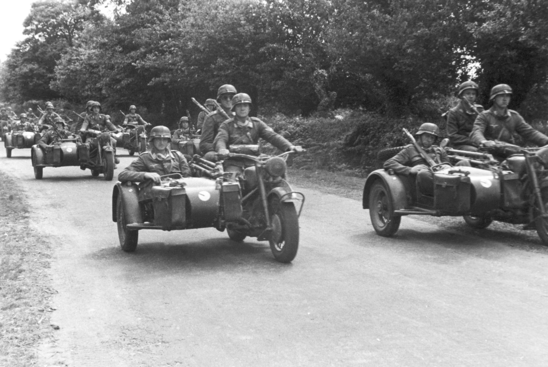 Wehrmacht soldiers ride BMW R 75 motorbikes with sidecars.