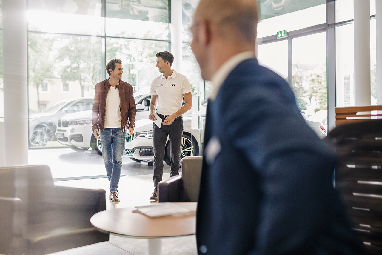 A customer is being advised by an employee of a BMW dealership.