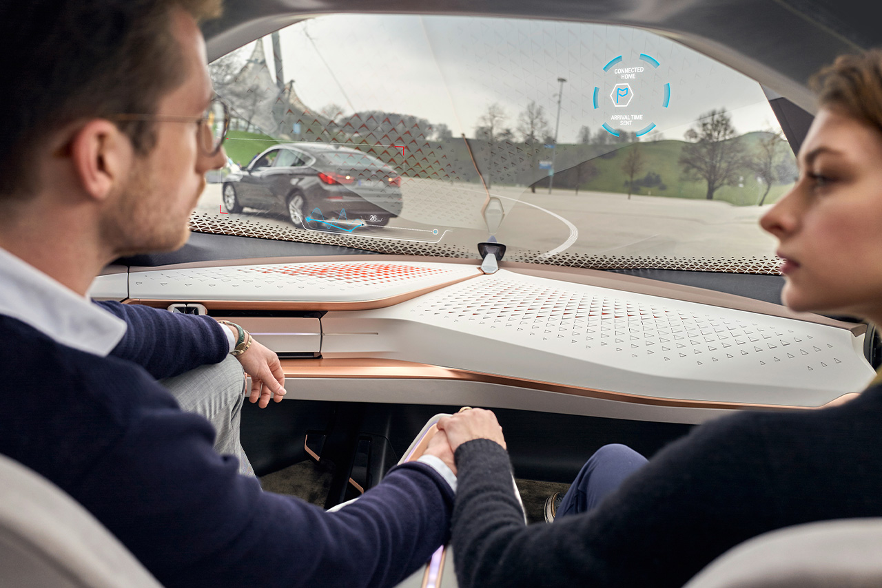 Autonomous driving: Two people converse in a vehicle without a steering wheel.