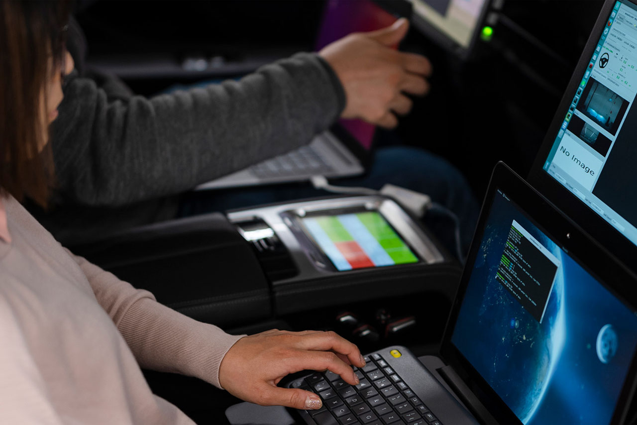 The tech team tests cars with their computers.