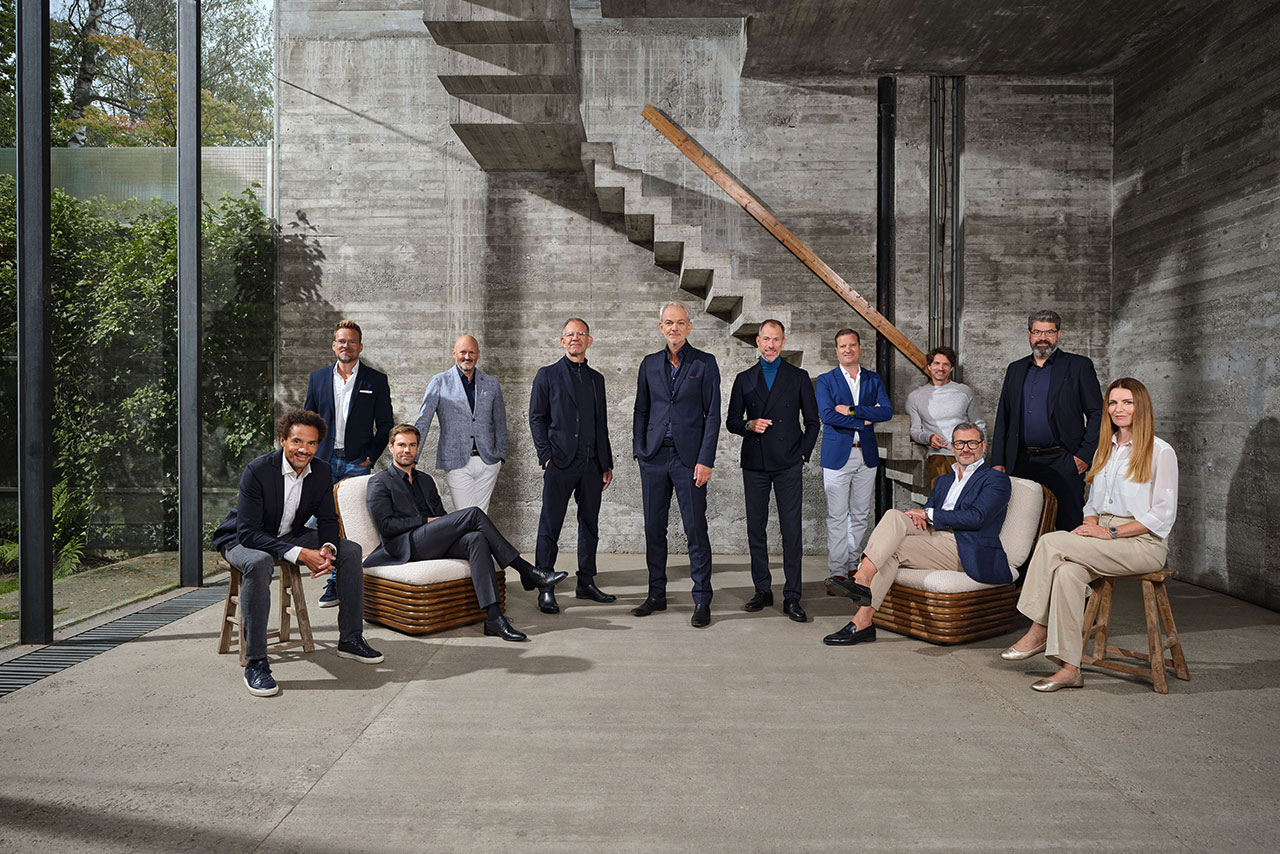 BMW Design Team posing together in a modern architectural setting.