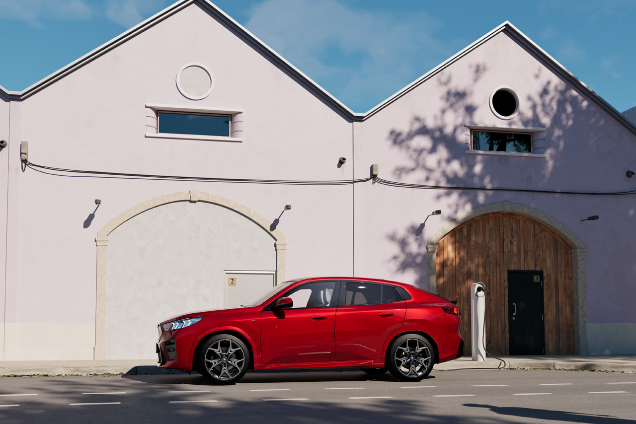 A red BMW iX2 parked on the street to charge.