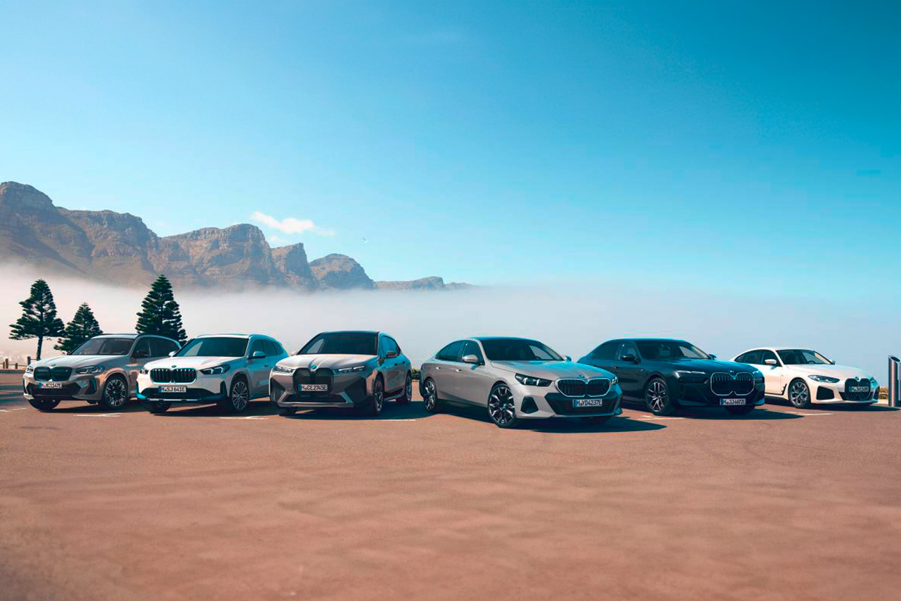 Six different electrified BMW vehicles are positioned infront of the mountains