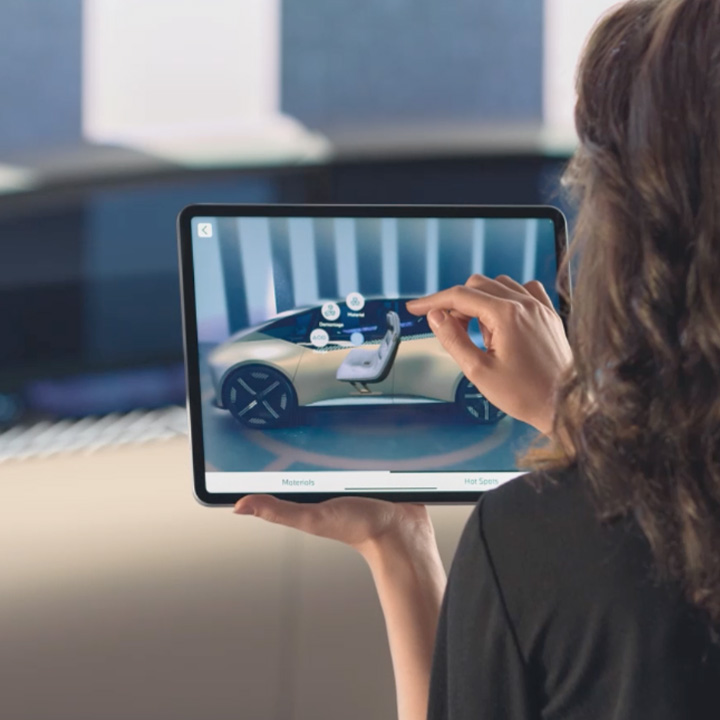 Frau schaut sich ein Auto auf dem Tablet an.