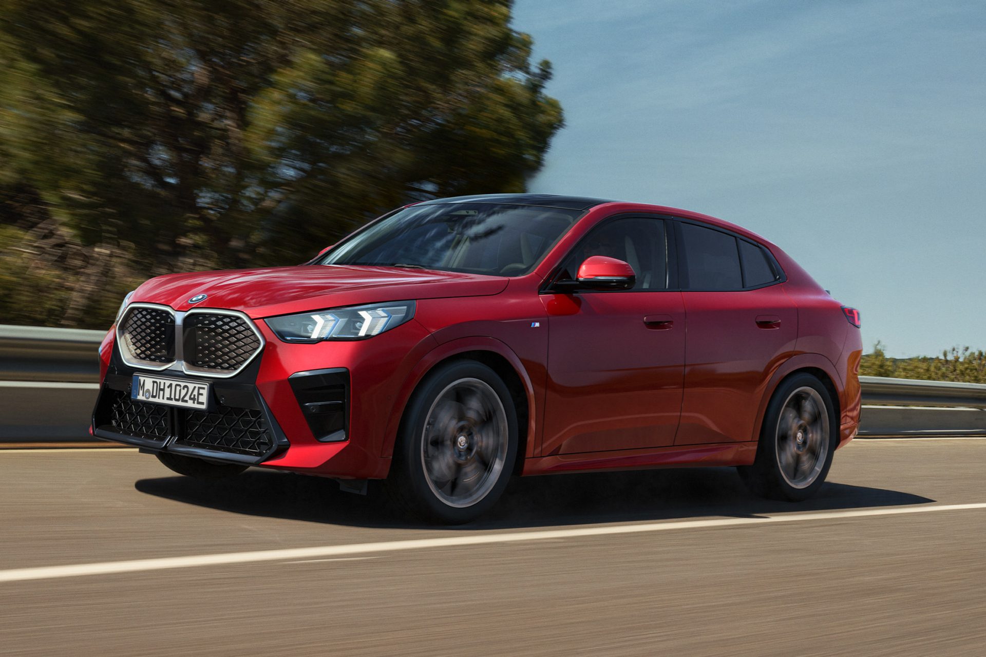 red BMW iX2 driving on a road