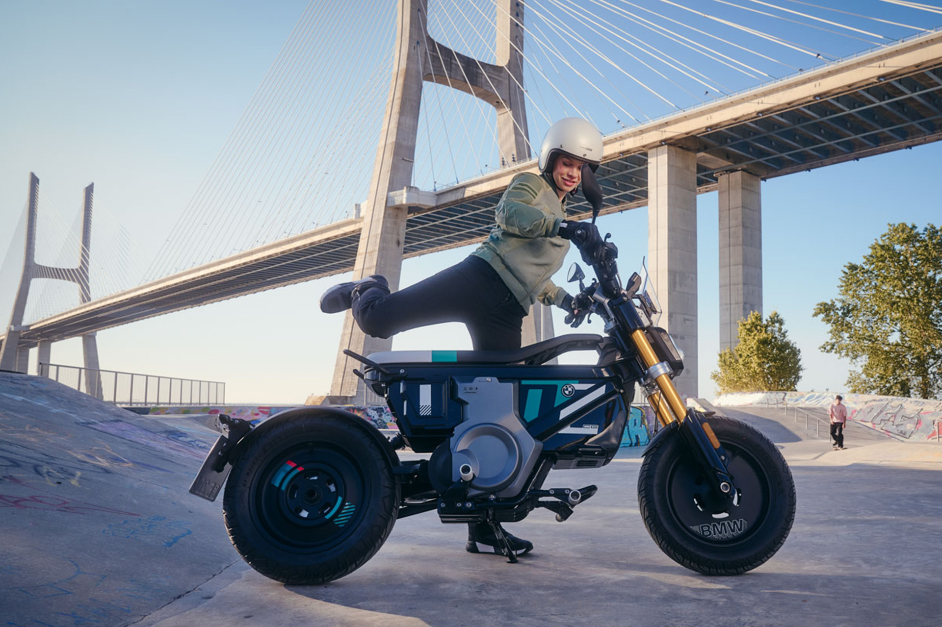 A young person is mounting onto the BMW CE 02.