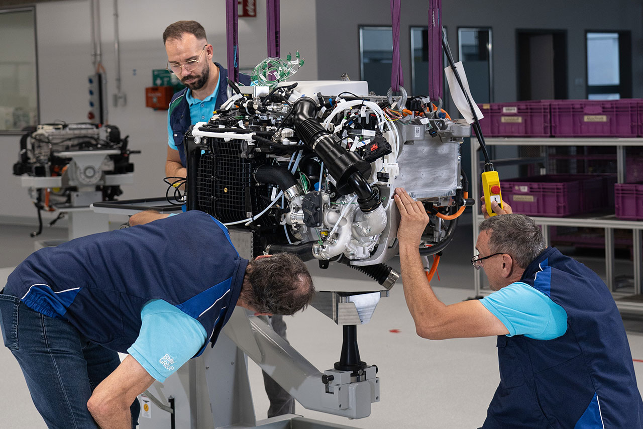 Three men are inspecting an engine. 