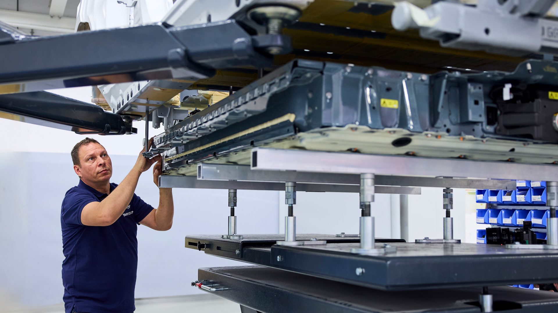 A BMW factory worker installs a BMW hydrogen flat storage tank in a BMW iX5 Hydrogen.