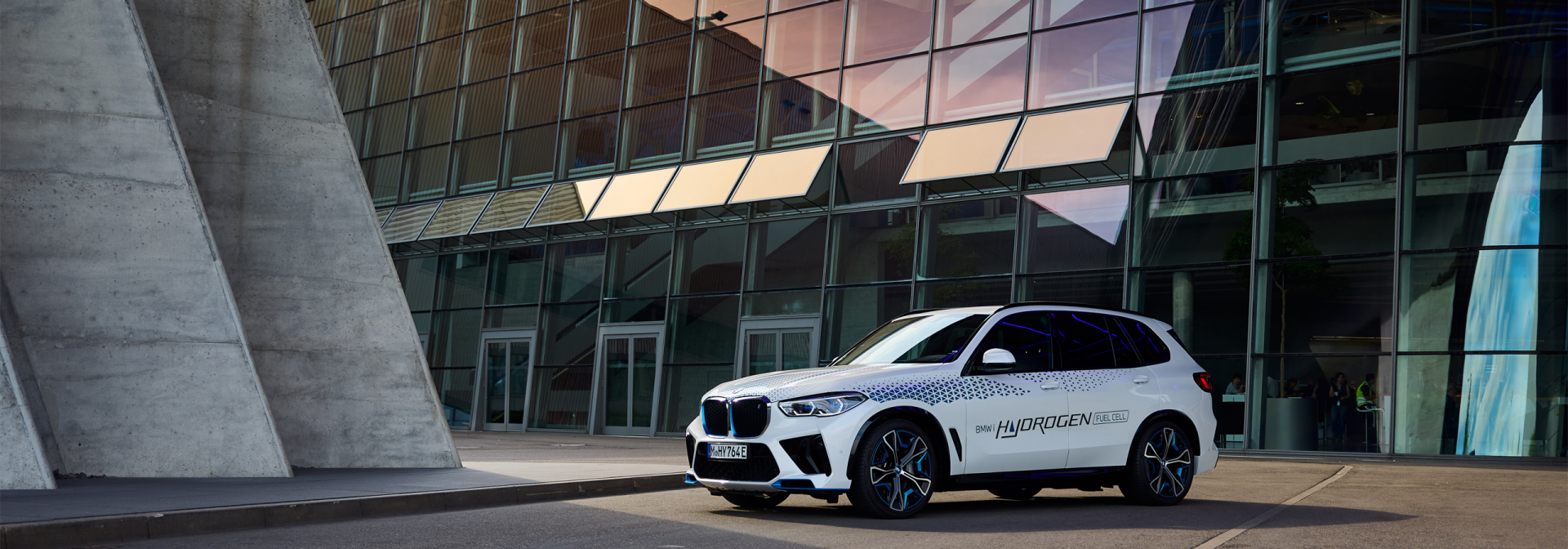 Ein Wasserstoff-betriebener BMW vor einem BMW Gebäude.