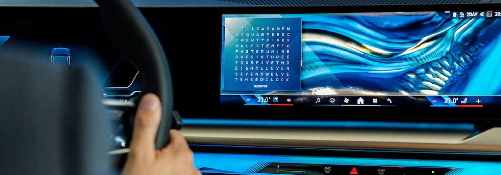 A hand grips a steering wheel. In the background, a screen displays blue and gray wave patterns along with a word search grid.